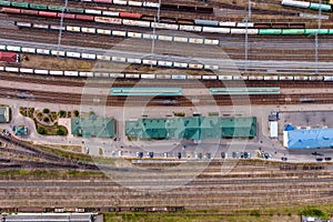 aerial view over long railway freight trains with lots of wagons stand on parking