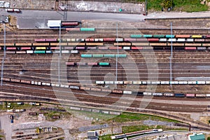 aerial view over long railway freight trains with lots of wagons stand on parking