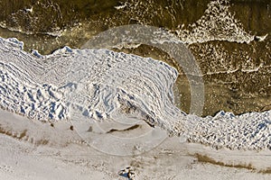 Aerial view over partialy frozen sea with white ice texture