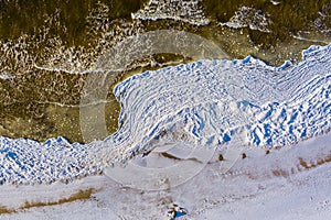 Aerial view over partialy frozen sea with white ice texture