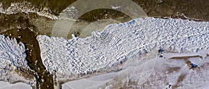 Aerial view over partialy frozen sea with white ice texture