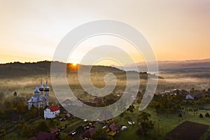 Aerial view over small rural village of Breb in magic sunrise