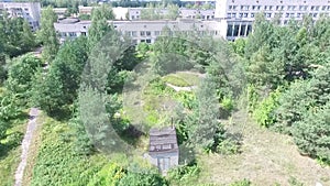 Aerial view over the small town. Aerial survey of buildings and trees. Flying over the yard and over people`s heads