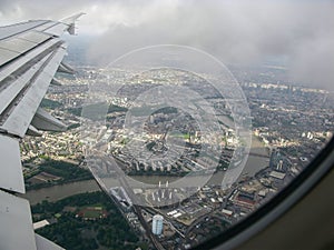 Aerial view over Thames river and London suburbs seen from airplane flying high above Nine Elms