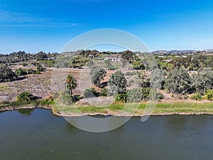 Aerial view over water reservoir and a large dam that holds water. Rancho Santa Fe in San Diego