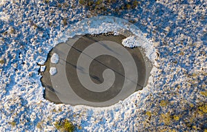 Aerial view over winterly snow and ice-clad peat bog landscape in natural Estonian