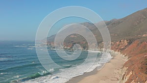 Aerial view, Pacific waves wash over the rugged coast of northern California. The Pacific Coast Scenic Highway runs