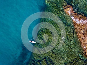 Aerial view of a paddle board in the water floating on a transparent sea, snorkeling. Bathers at sea. Tropea, Calabria, Italy photo