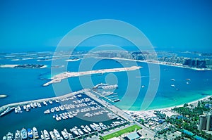 Aerial view of Palm Jumeirah Island with luxury yachts in the front.