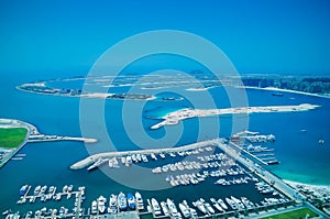 Aerial view of Palm Jumeirah Island with luxury yachts in the front.