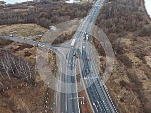 Aerial view a panorama of the high-speed highway running through the wood. The picture from the drone in the fall