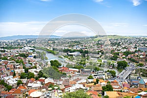 Aerial view panorama of old historic Tbilisi city center, mountains, architecture roofs buildings, river, Georgia in summer sunny