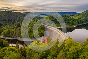 Aerial view on panorama of stone dam at reservoir with flowing water, hydroelectricity power station in Pilchowice