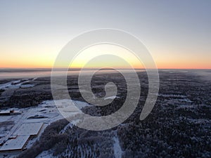 Aerial view a panoramic landscape of winter nature in the golden hour of dawn on a frosty morning. Panoramic shot from drone