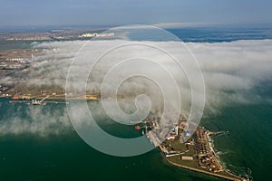 Aerial view of panoramic seaport warehouse and container ship, crane vessel working for delivery of delivery containers. Yuzhny