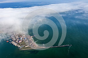 Aerial view of panoramic seaport warehouse and container ship, crane vessel working for delivery of delivery containers. Yuzhny