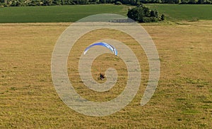 Aerial view of paramotor flying over the fields