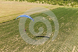 Aerial view of paramotor flying over the fields