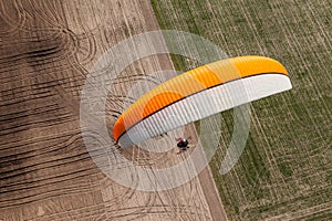 Aerial view of paramotor flying over the fields