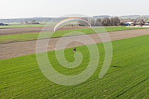 Aerial view of paramotor flying over the fields