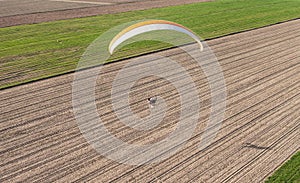 Aerial view of paramotor flying over the fields