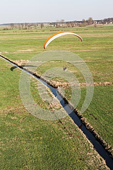 Aerial view of paramotor flying over the fields