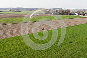 Aerial view of paramotor flying over the fields