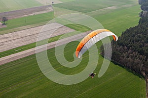 Aerial view of paramotor flying over the fields i