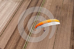 Aerial view of paramotor flying over the fields i