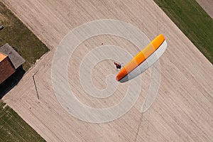 Aerial view of paramotor flying over the fields i