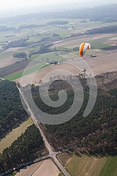 Aerial view of paramotor flying over the fields i