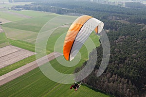 Aerial view of paramotor flying over the fields i