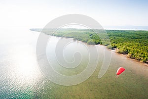 Aerial view, paramotor flying over the island at sunshine day. R