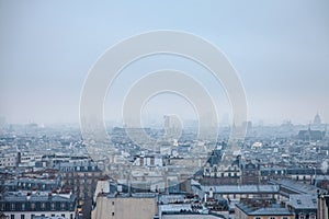 Aerial view of Paris, capital city of France, during a cold winter afternoon, with clouds and fog generated by pollution.