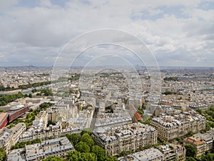 Aerial view of the Paris cityscape, with buildings going to a cloudy horizon