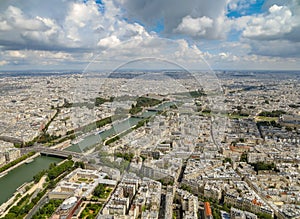 Aerial view of Paris cityscape including the River Seine under a cloudy blue sky