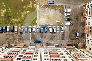 Aerial view of parked cars on parking lot between high apartment buildings