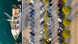 An aerial view of the parking lot with cars. Parking near the port. A docked ship. Photo from a drone.