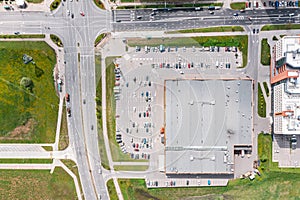 Aerial view of parking lot with many cars near shopping center