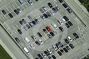 Aerial view of a parking lot with many cars in rows.