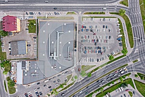 Aerial view of parking lot with parked cars of supermarket shopping center shoppers