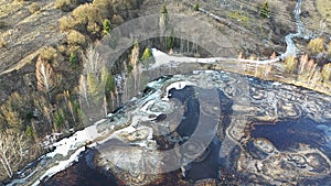 Aerial view of part of half frozen black gudron toxic waste tar pit during winter season.