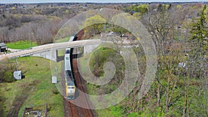 Aerial view of a passenger train entering town around a curve