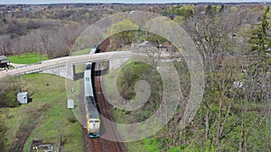 Aerial view of a passenger train entering town around a curve 4K