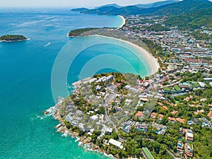 Aerial view of Patong beach with blue turquoise seawater, mountain hills, and tropical green forest trees with Andaman sea in