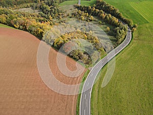 Aerial view of a paved road in the countryside on a warm day in autumn