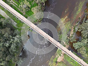 Aerial view of a Pedestrian footbridge over tanin coloured Avon River, Toodyay, Western Australia