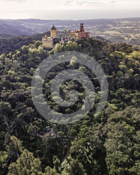 Aerial view of Pena Palace, a colourful Romanticist castle building on hilltop during a beautiful sunset, Sintra, Lisbon, Portugal