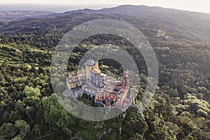 Aerial view of Pena Palace, a colourful Romanticist castle building on hilltop during a beautiful sunset, Sintra, Lisbon, Portugal