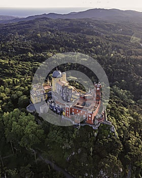 Aerial view of Pena Palace, a colourful Romanticist castle building on hilltop during a beautiful sunset, Sintra, Lisbon, Portugal